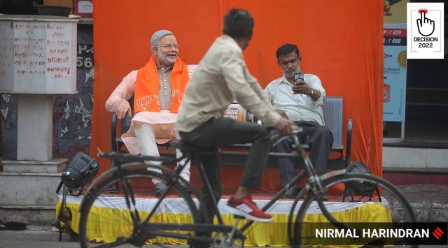 A passer-by clicks a selfie with a statue of PM Narendra Modi outside the office of BJP's Jamalpur-Khadia candidate Bhushan Bhatt in Ahmedabad on Monday. (Express Photo by Nirmal Harindran)