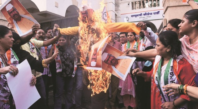 NCP workers burn an effigy and posters of Maharashtra Agriculture Minister Abdul Sattar in Thane on Monday. (Express photo by Deepak Joshi)