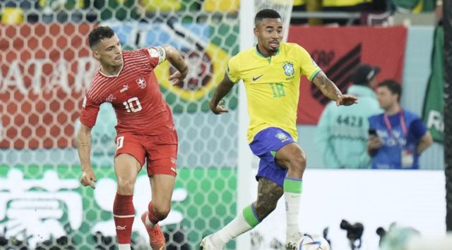 Brazil's Gabriel Jesus, right, and Switzerland's Granit Xhaka challenge for the ball during the World Cup group G soccer match between Brazil and Switzerland at the Stadium 974 in Doha, Qatar, Monday, Nov. 28, 2022. (AP Photo/Hassan Ammar)