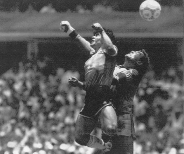 FILE - Argentina's Diego Maradona, left, beats England goalkeeper Peter Shilton to a high ball and scores his first of two goals in a World Cup quarterfinal soccer match, in Mexico City on June 22, 1986. This goal has gone down as the "Hand of God" as Maradona used his left fist to knock a ball past England's Shilton. (El Grafico, Buenos Aires via AP/File)