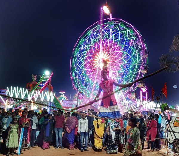 A child performing a balancing act during the Baliyatra in Odisha.