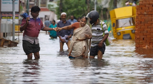 Chennai: Commuters wade through a waterlogged road following heavy rains, near Chennai, Sunday, Nov. 13, 2022. (PTI Photo)