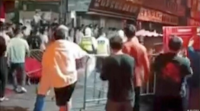 In this still image obtained from a video, people break through bariers in Guangzhou, China. (Reuters)