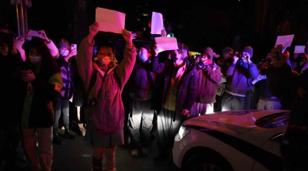 Protesters hold up blank papers and chant slogans as they march in protest in Beijing, Sunday, Nov. 27, 2022. Protesters angered by strict anti-virus measures called for China's powerful leader to resign, an unprecedented rebuke as authorities in at least eight cities struggled to suppress demonstrations Sunday that represent a rare direct challenge to the ruling Communist Party. (AP Photo/Ng Han Guan)