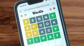 table with a smartphone kept on top, in which wordle is being played