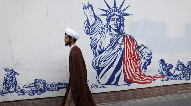 An Iranian cleric walks past an anti-US mural on the wall of former US Embassy during the 43rd anniversary of the US expulsion from Iran, in Tehran, Iran, Nov. 4, 2022. (Majid Asgaripour/WANA via Reuters)