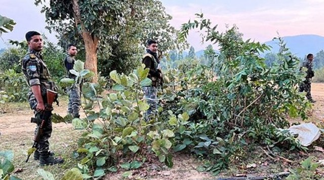  Security personnel stand near the mortal remains of one of the three maoist killed during an encouter, in Latehar district, Monday, Nov. 21, 2022. (PTI Photo) 
