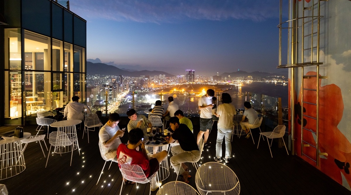 Customers at a rooftop bar in Busan, South Korea, on July 15, 2022. (Photographer: SeongJoon Cho/Bloomberg)