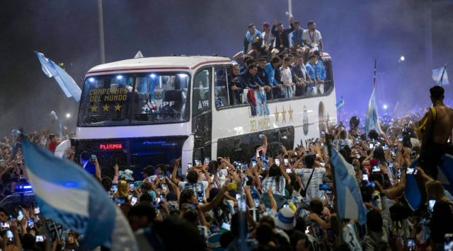 Soccer fans surround the bus taking the Argentine soccer team that won the World Cup to the Argentina Soccer Association grounds where they will spend the night after landing at Ezeiza airport on the outskirts of Buenos Aires, Argentina, Tuesday, Dec. 20, 2022. (AP)