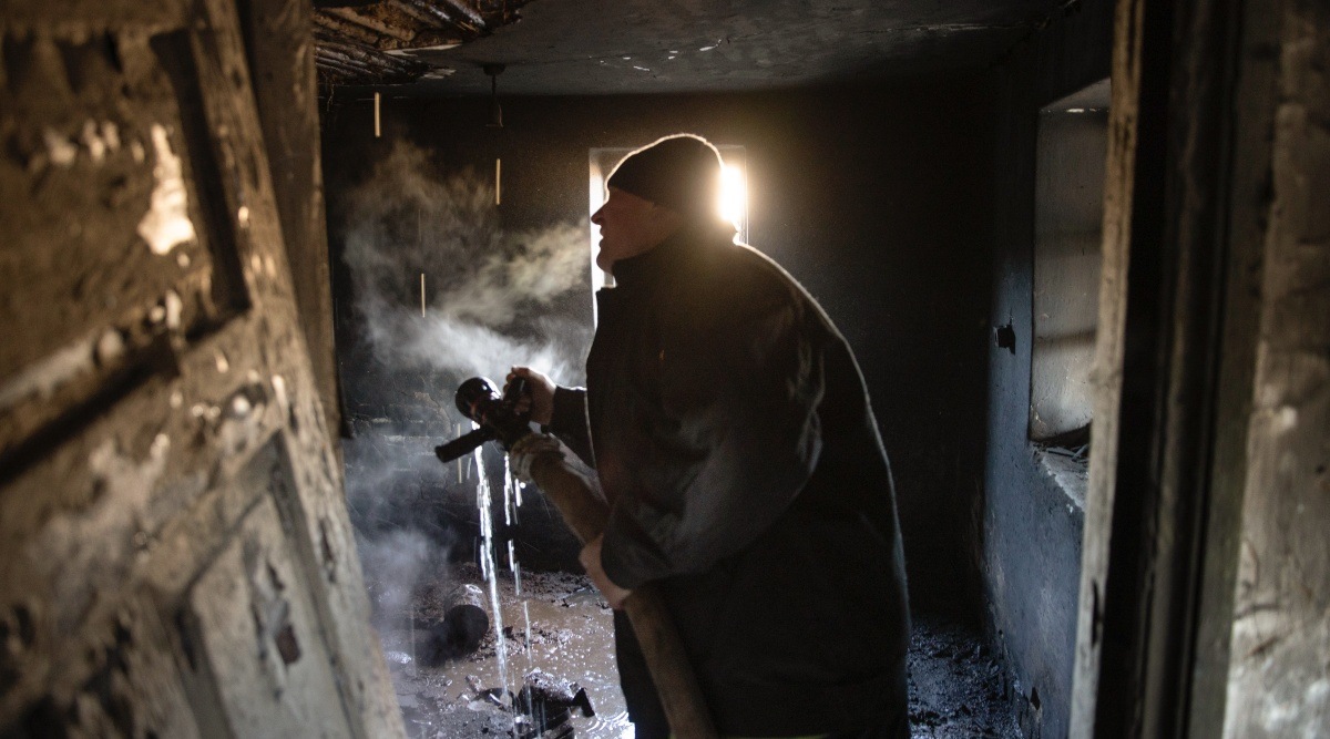 A firefighter from Emergency Service Department Number 21, the single working fire station in Lyman, Ukraine, extinguishing a fire in an abandoned home on Dec. 6, 2022. 
Firefighters in Lyman, in Ukraine’s east, contend with land mines, freezing temperatures, damaged buildings, awful cell service and a lack of water. (Tyler Hicks/The New York Times)
