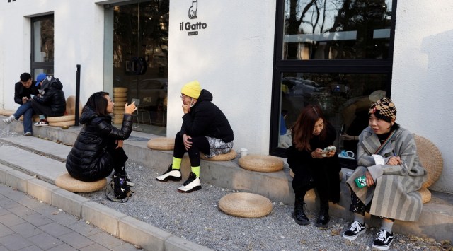 People sit outside a cafe after some curbs were lifted as coronavirus disease (COVID-19) outbreaks continue in Beijing, December 7, 2022. (REUTERS/File)