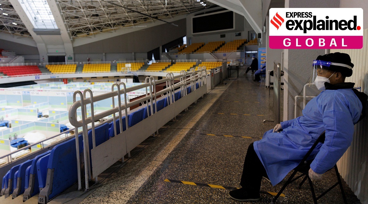 A security guard keeps watch in a makeshift fever clinic that was set up in a sports area. amid rising covid cases.
