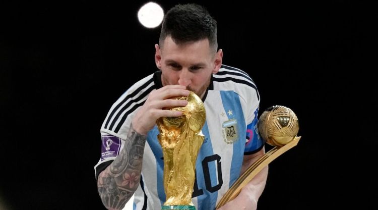 Argentina's Lionel Messi lisses the trophy after winning the World Cup final soccer match between Argentina and France at the Lusail Stadium in Lusail, Qatar, Sunday, Dec. 18, 2022. Argentina won 4-2 in a penalty shootout after the match ended tied 3-3. (AP)