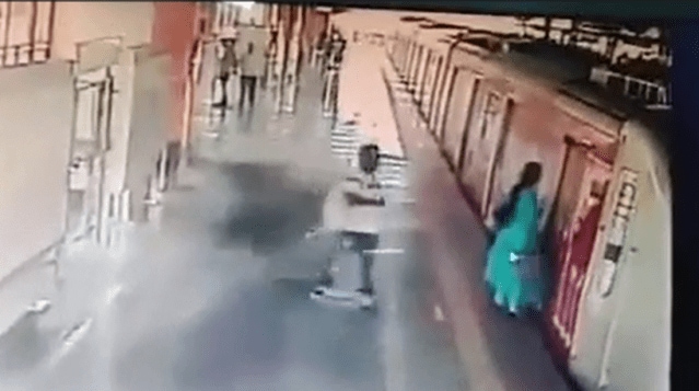 Woman in a green dress trying to rescue herself as her dress gets stuck between metro doors and a nearby commuter rushing for help (Image-Screengrab/video)