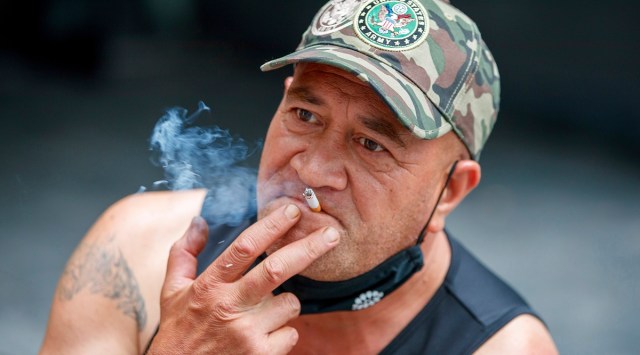 A man sits while smoking in Auckland, New Zealand, Thursday, Dec. 9, 2021. (AP/File)