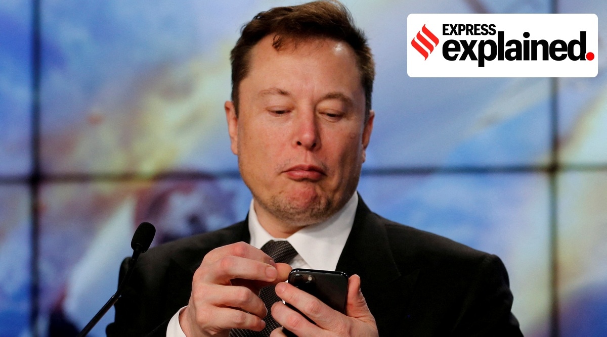 Elon Musk looks at his mobile phone.