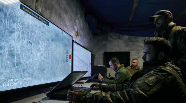 Ukrainian soldiers watch drone feeds from an underground command center in Bakhmut, Donetsk region, Ukraine, Sunday, Dec. 25, 2022. The Ukrainian government minister in charge of technology says his country has bought some 1,400 drones, mostly for reconnaissance, and is now developing air-to-air combat ones that can attack the drones Russia is using against Ukrainians. (AP Photo)