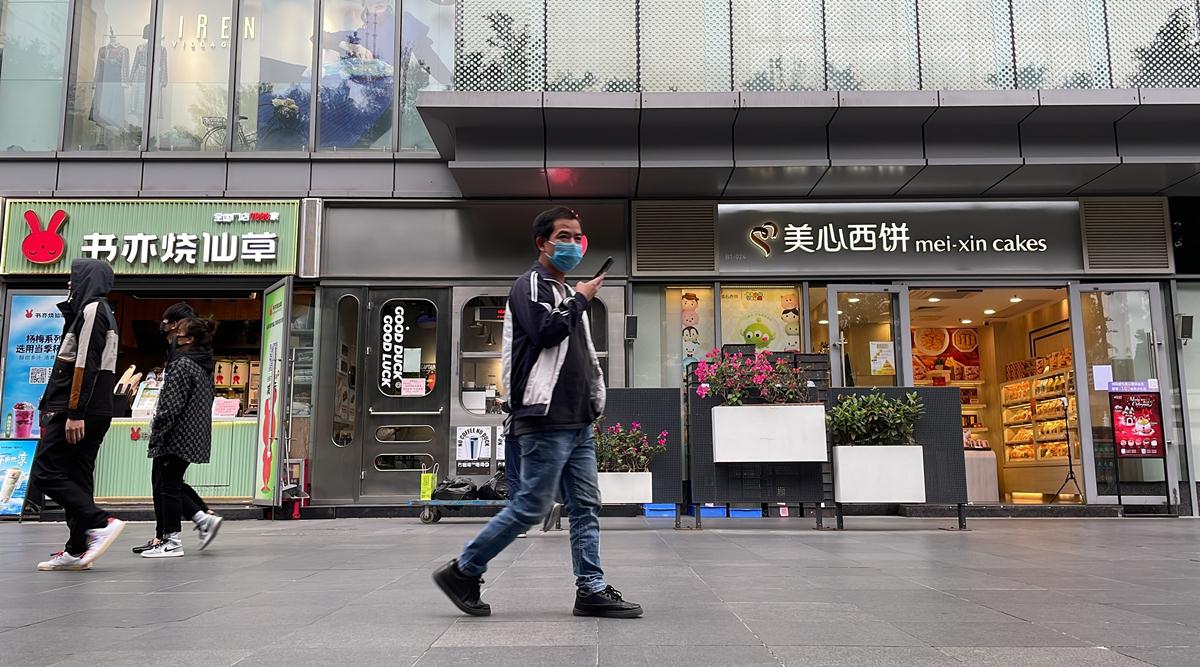 Residents walk past shops reopened in the district of Haizhu as pandemic restrictions are eased in southern China's Guangzhou province, on December 1, 2022. (AP Photo)