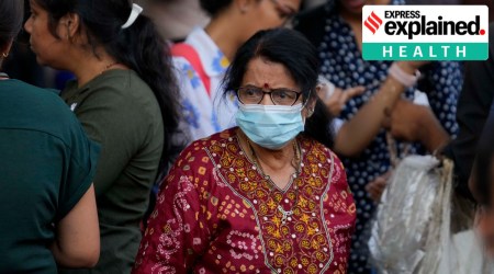 A woman wearing a face mask walks through a busy shopping district in Mumbai, India, Thursday, Dec. 22, 2022.  (AP Photo/Rafiq Maqbool)