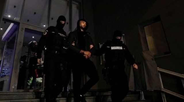 Andrew Tate and Tristan Tate (not pictured) are escorted by police officers outside the headquarters of the Directorate for Investigating Organized Crime and Terrorism in Bucharest (DIICOT) after being detained for 24 hours, in Bucharest, Romania (Reuters)