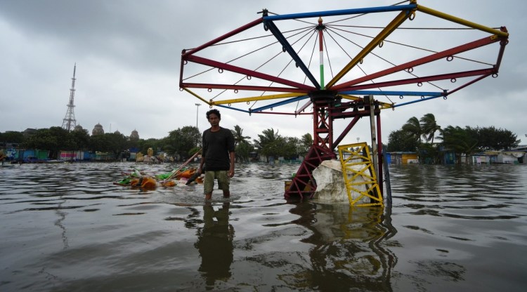 Chennai: A man walks through a waterlogged area after the landfall of Cyclone Mandous, at Marina beach in Chennai, Saturday, Dec. 10, 2022. (PTI Photo/R Senthilkumar)  