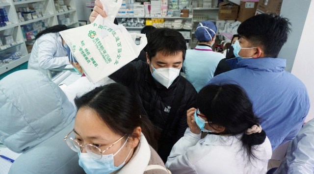 People line up to buy antigen test kits for the coronavirus disease (COVID-19), at a pharmacy in Hangzhou, Zhejiang province, China, Dec. 19, 2022. (China Daily via Reuters)
