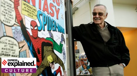 Stan Lee standing next to a Spiderman poster