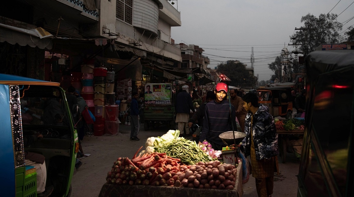 Vendors sell fruit under lights lit by batteries in Lahore on Jan. 23. (Photographer: Betsy Joles/Bloomberg)