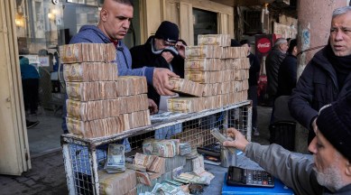 A man exchanges US dollars for stacks of Iraqi dinar in the main Shurja market in central Baghdad. (AP)