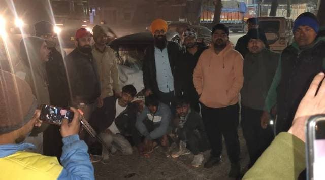 Cow vigilantes with Waris and his two associates in front of their Santro. One of the men is seen with a gun.