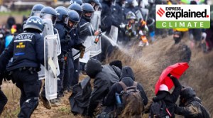 Police officers spray activists, who attempt to block the impact using an umbrella, during a protest against the expansion of Germany's utility RWE's Garzweiler open-cast lignite mine to Luetzerath, Germany.
