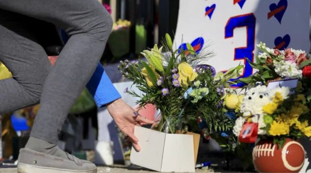 A person leaves flowers for the display set-up for Buffalo Bills' Damar Hamlin outside of University of Cincinnati Medical Center, Wednesday, Jan. 4, 2023, in Cincinnati. Hamlin was taken to the hospital after collapsing on the field during the Bill's NFL football game against the Cincinnati Bengals on Monday night. (AP)