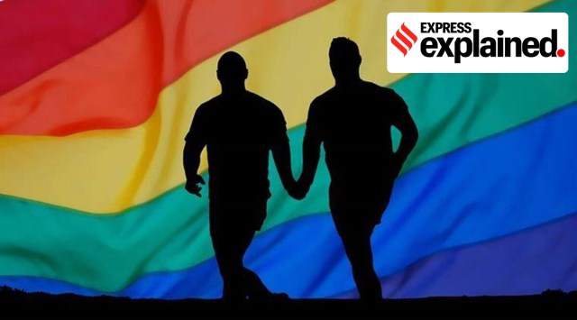 Two men running in front of a rainbow flag