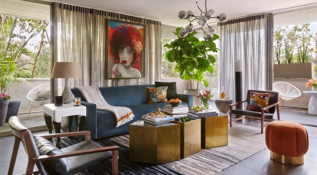 This image provided by John McClain Design shows the living room of a residence with a blue velvet sofa. In designer John McClain's own Hollywood Hills home, this room is a neutral envelope for the blue velvet sofa. (AP Photo)