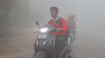 Students are going to their school during dense fog during extreme
