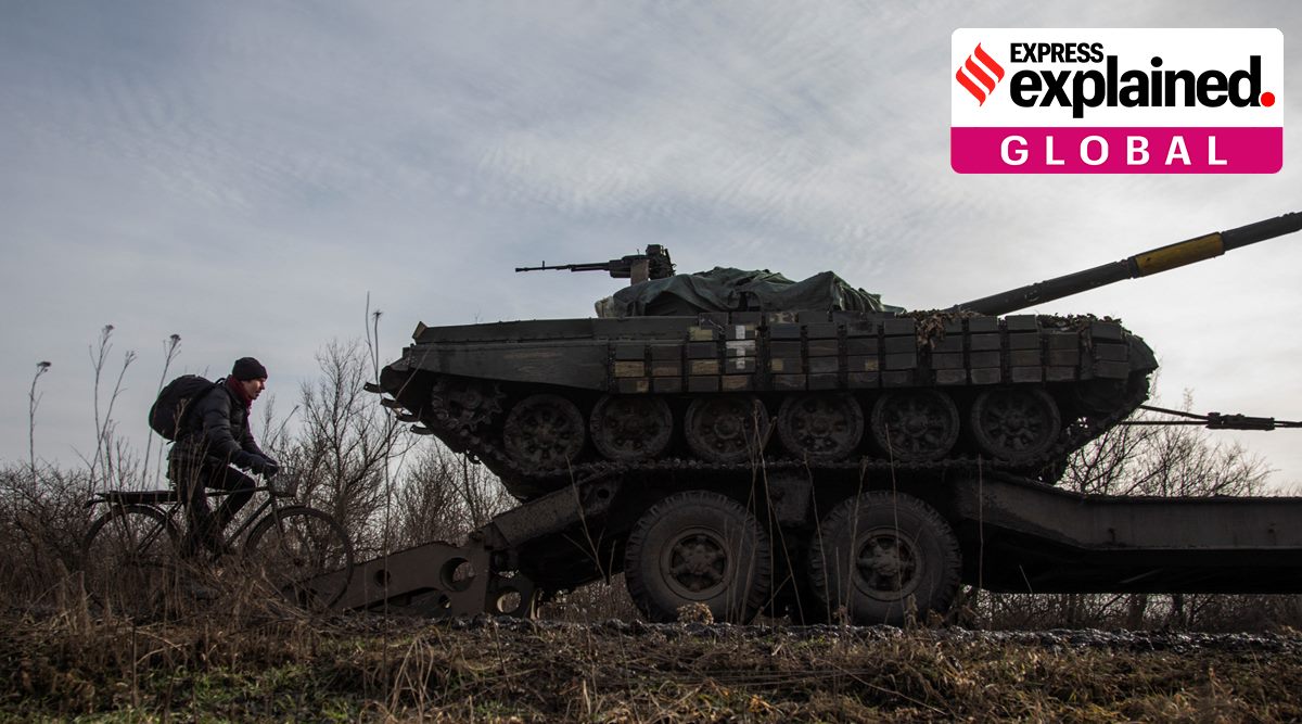 A local resident rides on a bicycle alongside a broken Ukrainian tank to a truck near the frontline town of Bakhmut, amid Russia's attack on Ukraine, in Donetsk region, Ukraine January 20, 2023. (Reuters Photo: Oleksandr Ratushniak, File)
