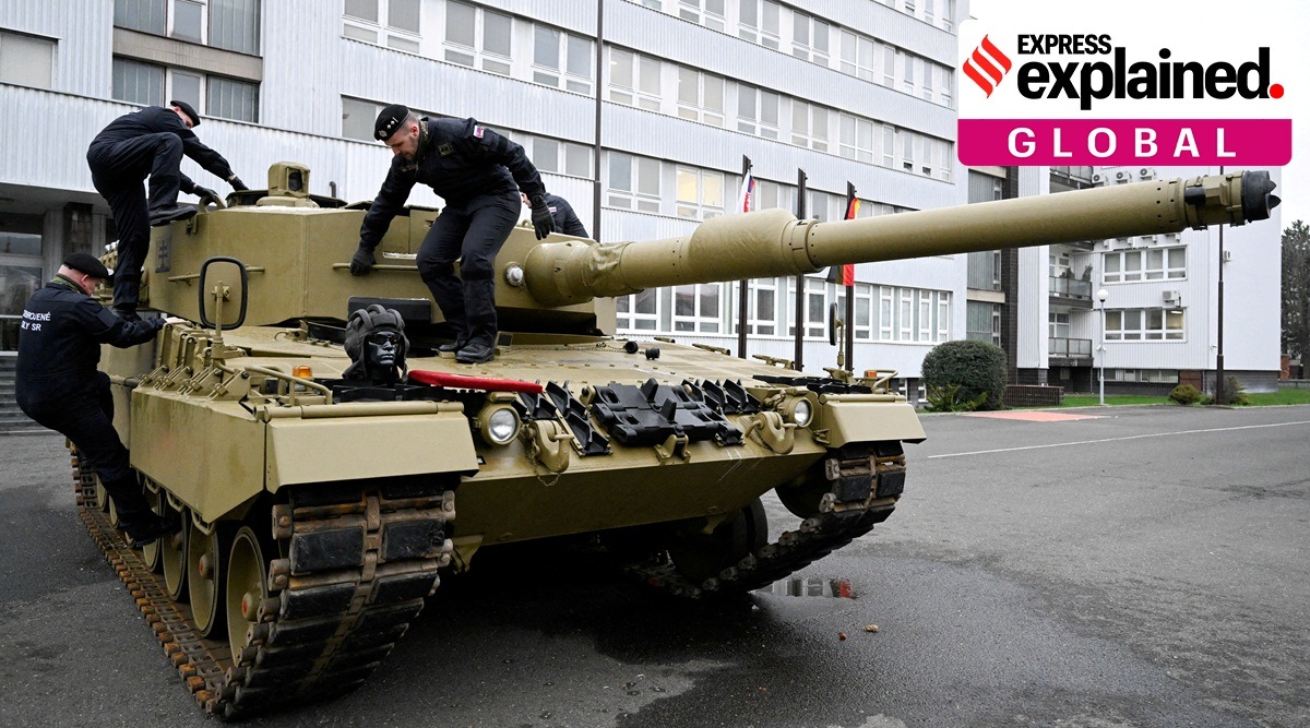 Members of the military walk on a tank in Slovakia