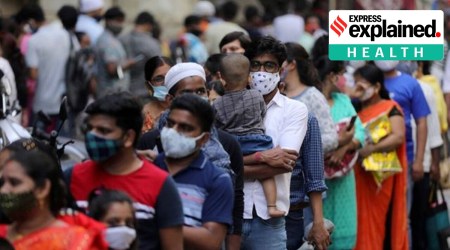 People standing in a queue, wearing masks.