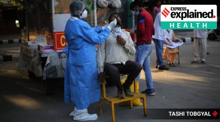 A medical worker in PPE administering a Covid-19 swab test.