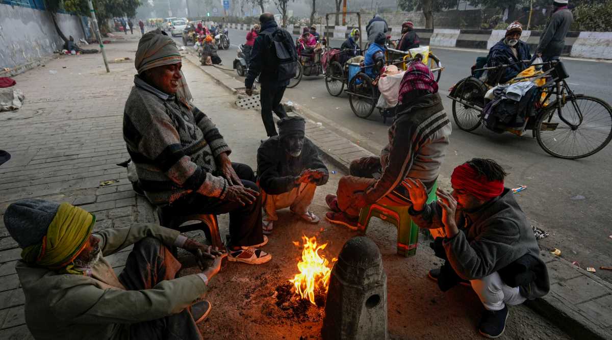 People warm themselves near a small fire during a cold and foggy winter morning, in New Delhi, Thursday, Jan 5, 2023. (PTI Photo)  
