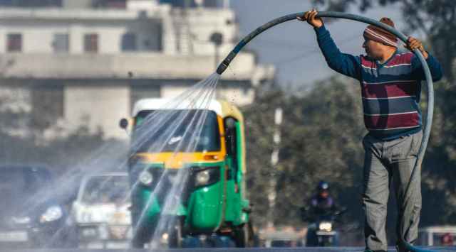 An MCD worker sprays water as part of measures to curb air pollution, at Okhla in New Delhi, Wednesday, Dec. 28, 2022. (PTI Photo)