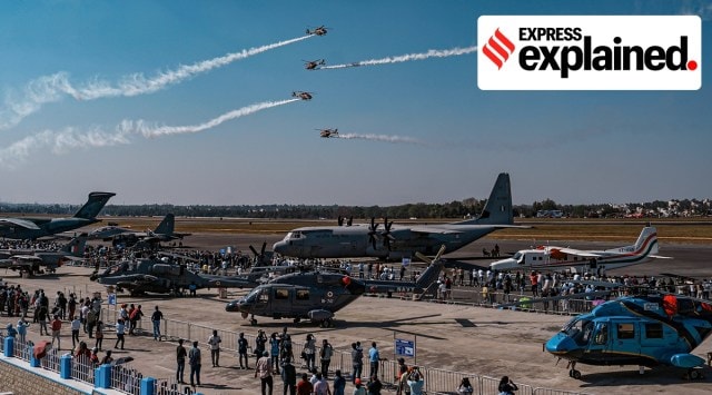 IAF helicopters fly overhead as visitors look at aircraft at Aero India last week. PTI