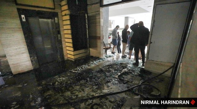 Residents check the aftermath of the fire that broke out in the electrical duct of a high-rise building, Takshashila Air, in the Ellisbridge area of Ahmedabad. (Express photo by Nirmal Harindran)