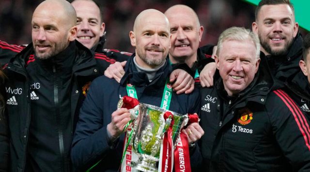 Manchester United's head coach Erik ten Hag, centre, and team members pose with the trophy after the English League Cup final soccer match between Manchester United and Newcastle United at Wembley Stadium in London, Sunday, Feb. 26, 2023. (AP Photo/Alastair Grant)