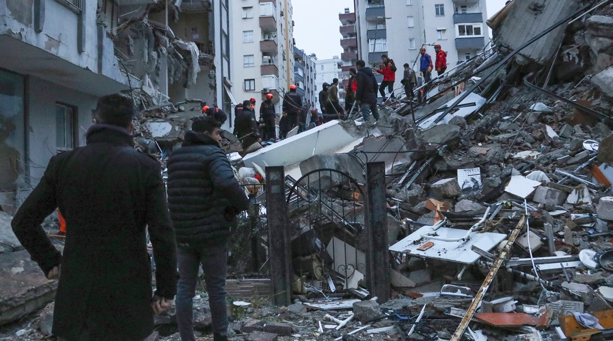 People and rescue teams try to reach trapped residents inside collapsed buildings in Adana, Turkey, on Monday. (Photo: AP)