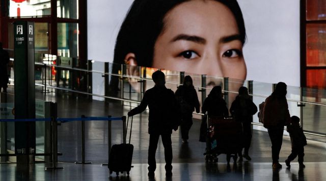 Travellers walk with luggages at a terminal hall, during the annual Spring Festival travel rush ahead of the Chinese Lunar New Year, as the coronavirus disease (COVID-19) outbreak continues, in Beijing Capital International Airport. (Reuters)