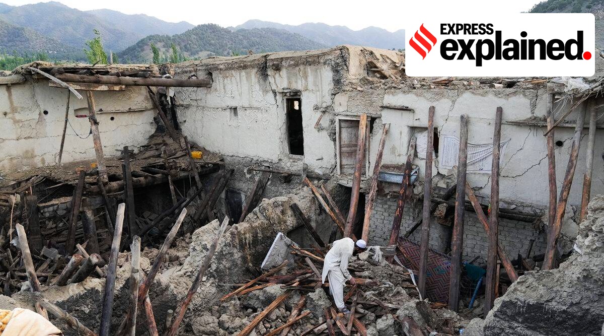 A man sorts through the rubble of his house.