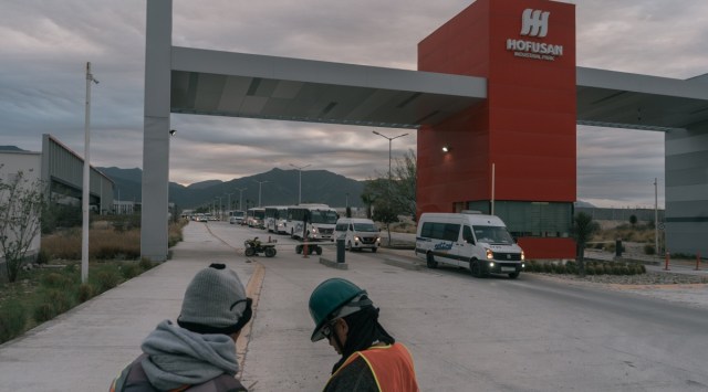 Workers wait for a taxi outside of the Hofusan industrial park, a venture of a local developer and two companies from China, in Nuevo León, Mexico, Jan. 19, 2023. Alarmed by shipping chaos and geopolitical fractures, exporters from China are setting up factories in Mexico to preserve their sales to the United States. (Luis Antonio Rojas/The New York Times)