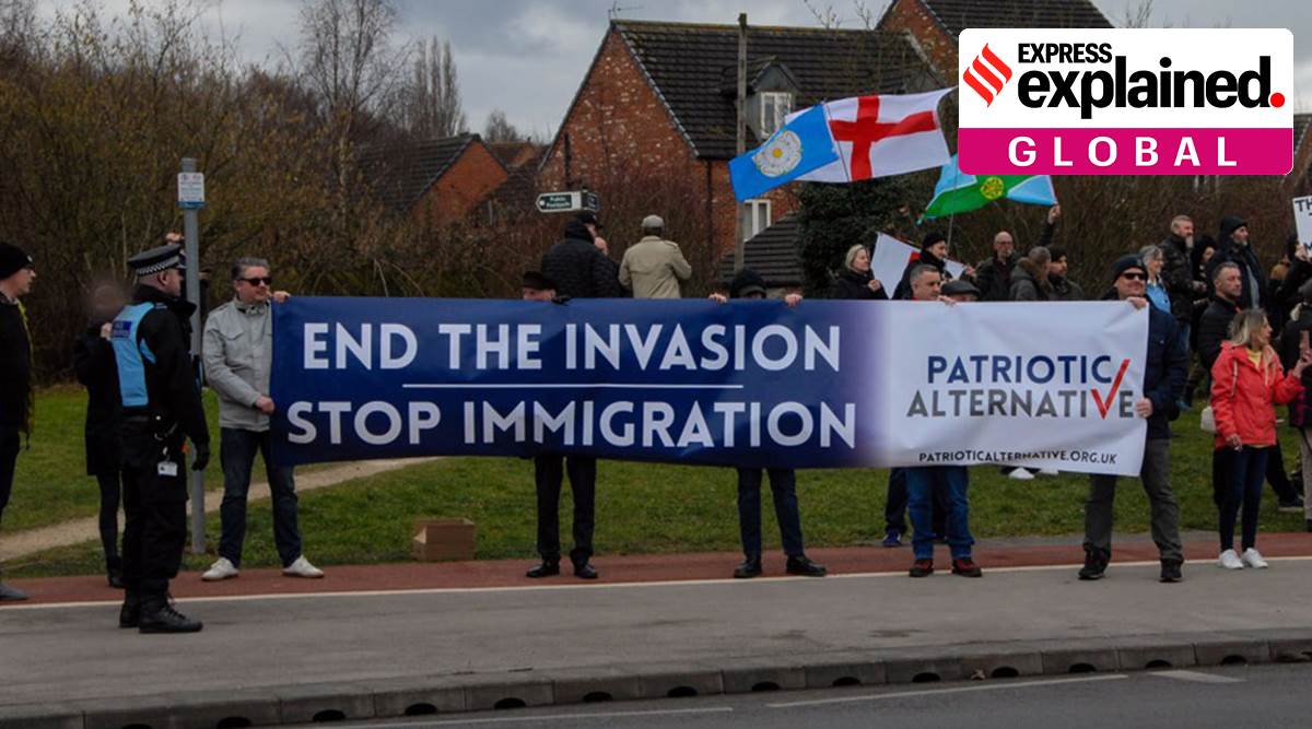 Protestors hold a banner saying 'End the invasion, stop immigration' in a UK town.