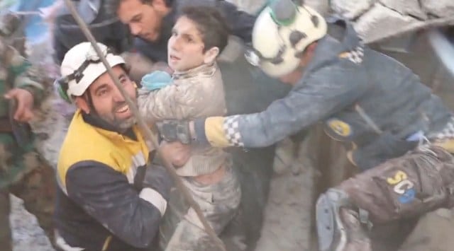 The White Helmet volunteers rescue a child from under rubble, in the aftermath of a deadly earthquake, in Jandaris, Syria February 8, 2023, in this still image obtained from a social media video. (The White Helmets/via Reuters)